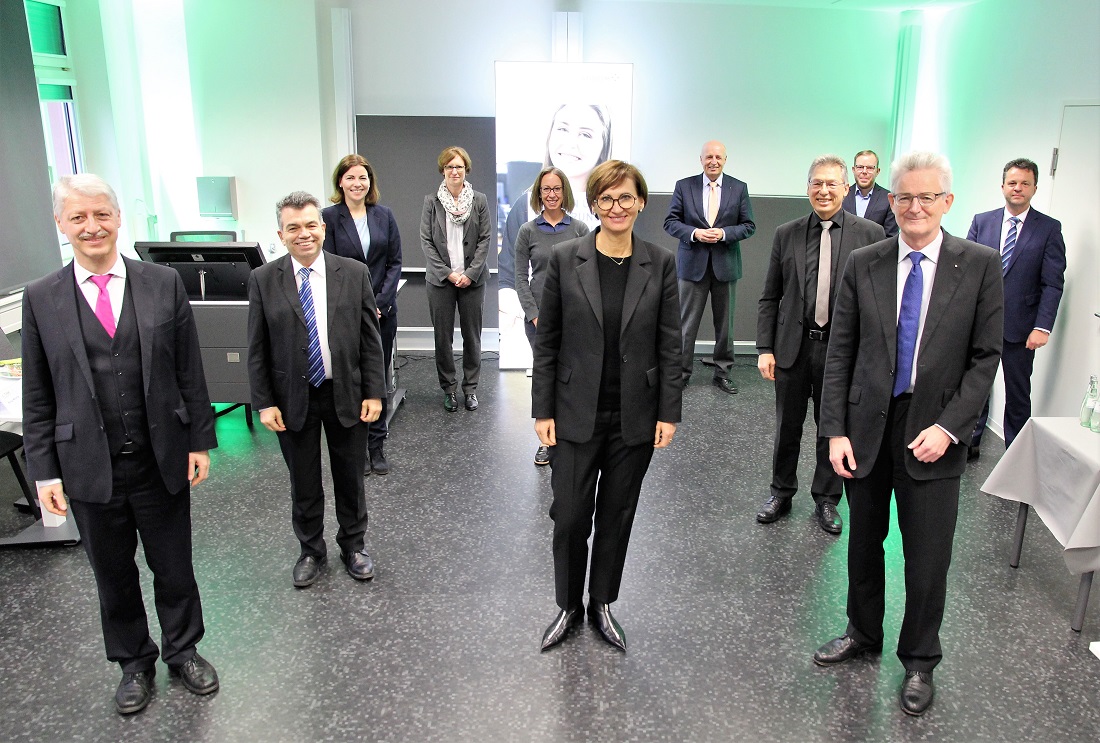 Eine Gruppe von Menschen steht in einem Raum mit grünem Licht.