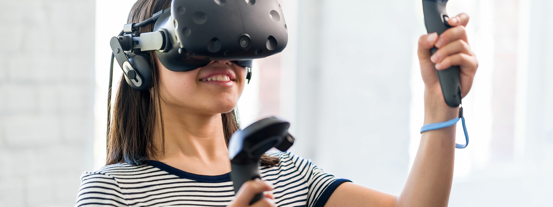Eine Frau trägt eine VR-Brille und taucht in eine virtuelle Realität ein.