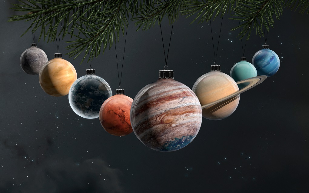 Weihnachtskugeln, die wie Planteten aussehen an einem Zweig