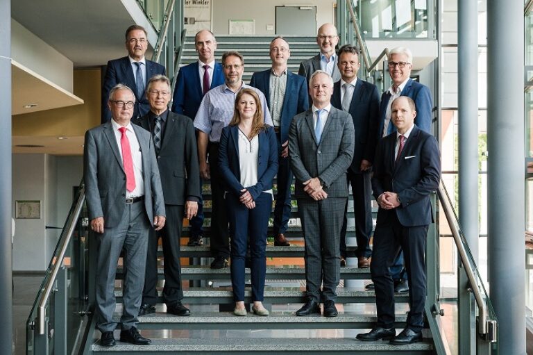 Eine Gruppe von Personen in Geschäftsanzügen steht auf einer Treppe.