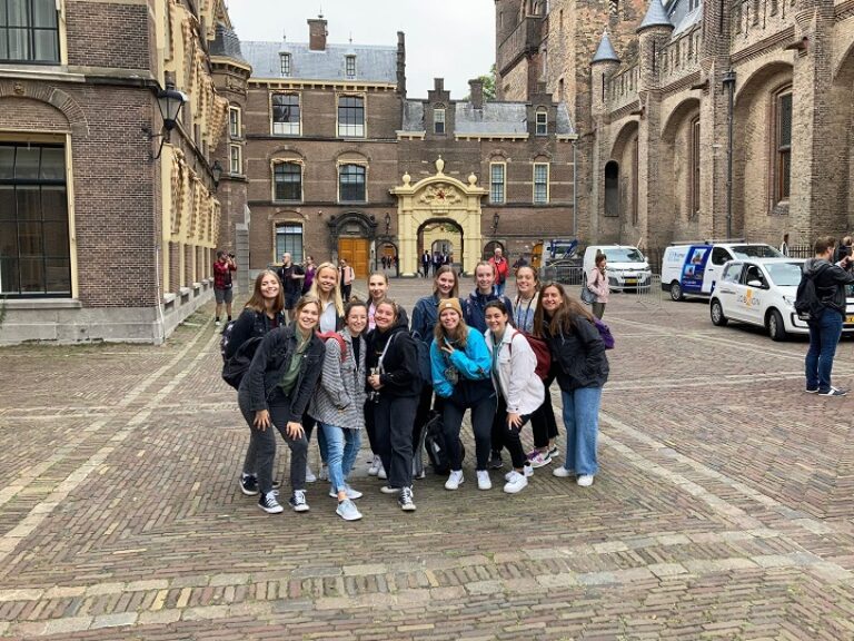 Eine Gruppe von Menschen posiert vor einem Gebäude für ein Foto.