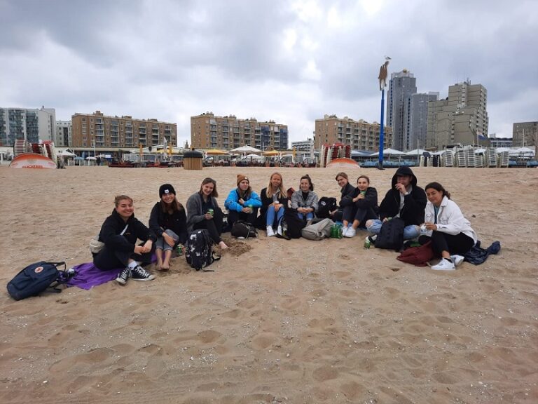 Eine Gruppe Menschen sitzt am Strand und genießt das Meer.