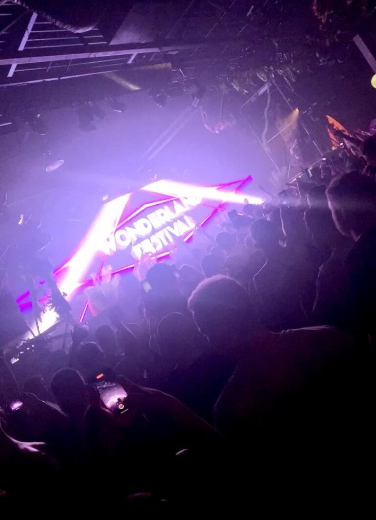Eine Menschenmenge in einem Nachtclub mit lila Lichtern.