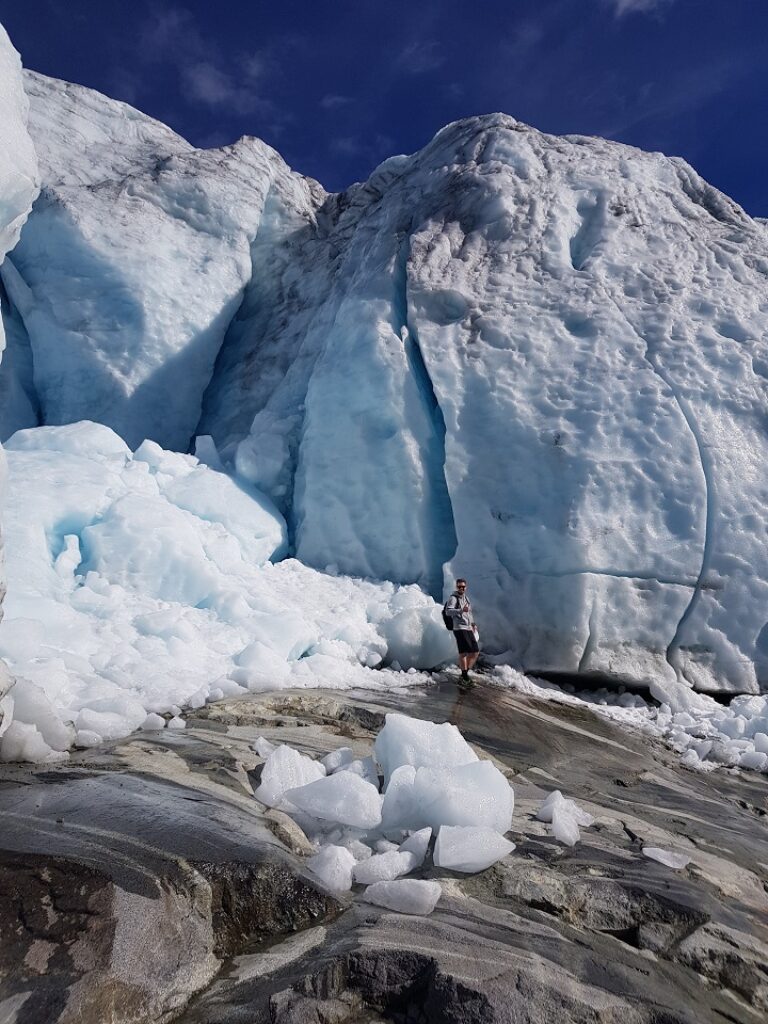 Eine Person steht neben dem Eisberg.