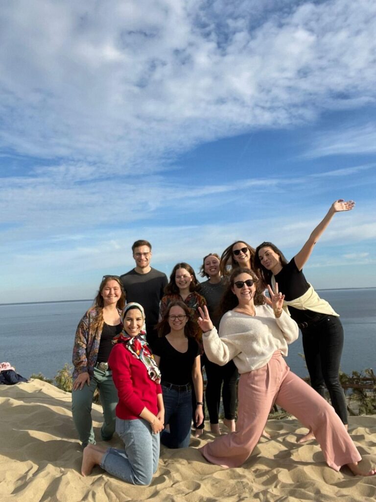 Menschen posieren für ein Foto auf einer Sanddüne.
