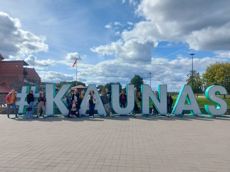 Eine Gruppe von Menschen steht vor dem Wort "Kaunas".