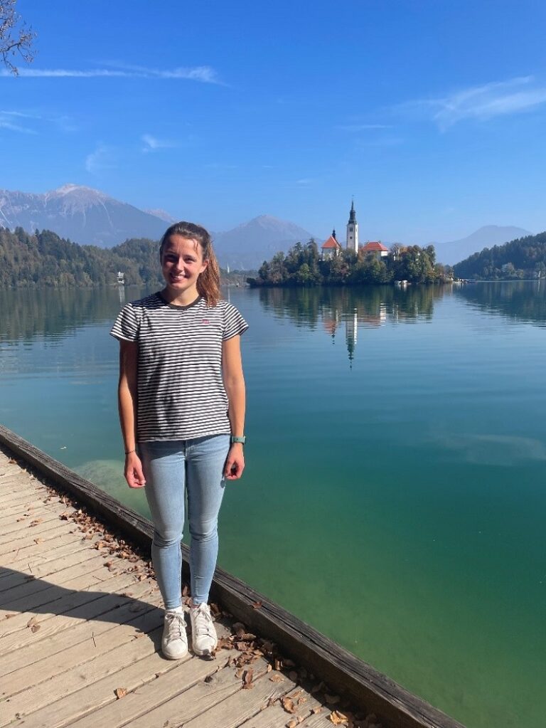 Ein Mädchen steht auf einem Steg vor dem Bleder See.
