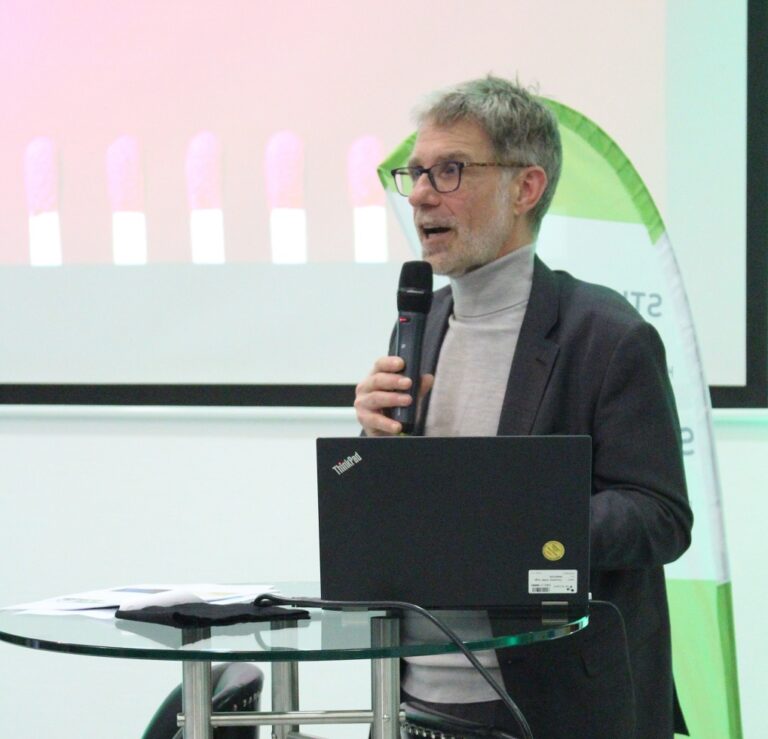 Ein Mann mit Brille hält eine Präsentation.