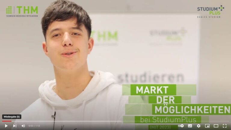 Ein Mann mit weißer Kapuzenjacke spricht in eine Kamera.