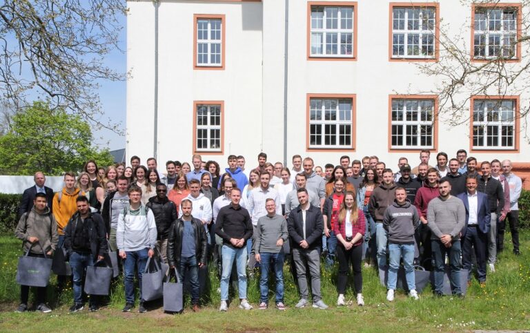 Eine Gruppe von Menschen steht vor einem Gebäude.