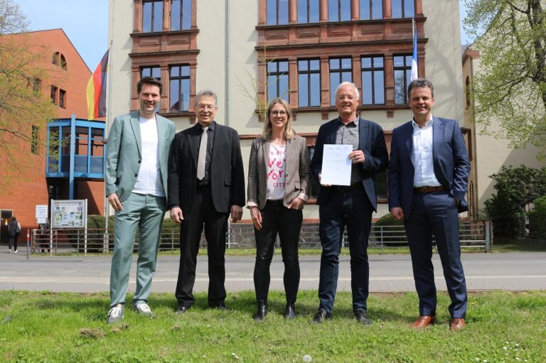 Eine Gruppe von Menschen steht vor einem Gebäude.
