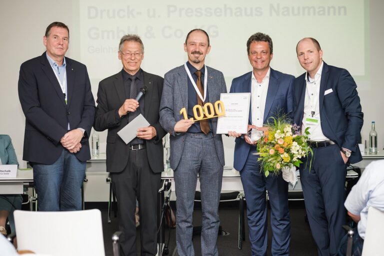 Eine Gruppe Männer steht vor einem Tisch.