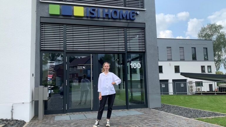 Eine Frau steht vor einem Gebäude.