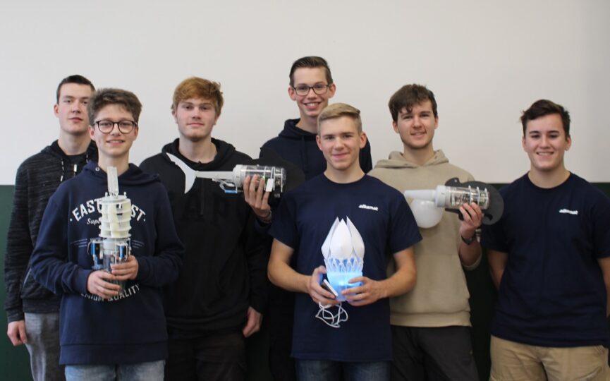 Eine Gruppe junger Männer hält stolz ihre Roboter .