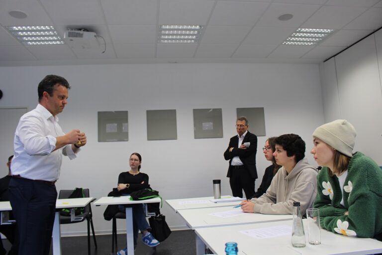 Ein Mann hält eine Präsentation vor einer Gruppe von Menschen.