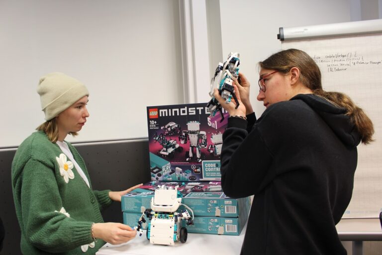 Zwei Frauen schauen sich einen Roboter an.