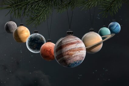 Weihnachtskugeln, die wie Planteten aussehen an einem Zweig