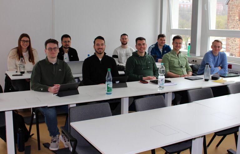 Neun Studierende sitzen im Hörsaal