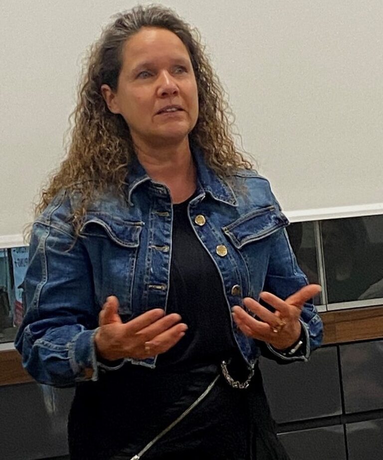 Frau Pia Meier in Jeansjacke spricht angeregt und teilt ihre Gedanken und Ideen.