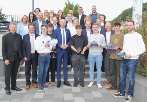 Die Praktikanten von PraktikumPlus stehen gemeinsam mit dem Kulturminister sowie Vertretern aus Politik und Wirtschaft auf einer Treppe.